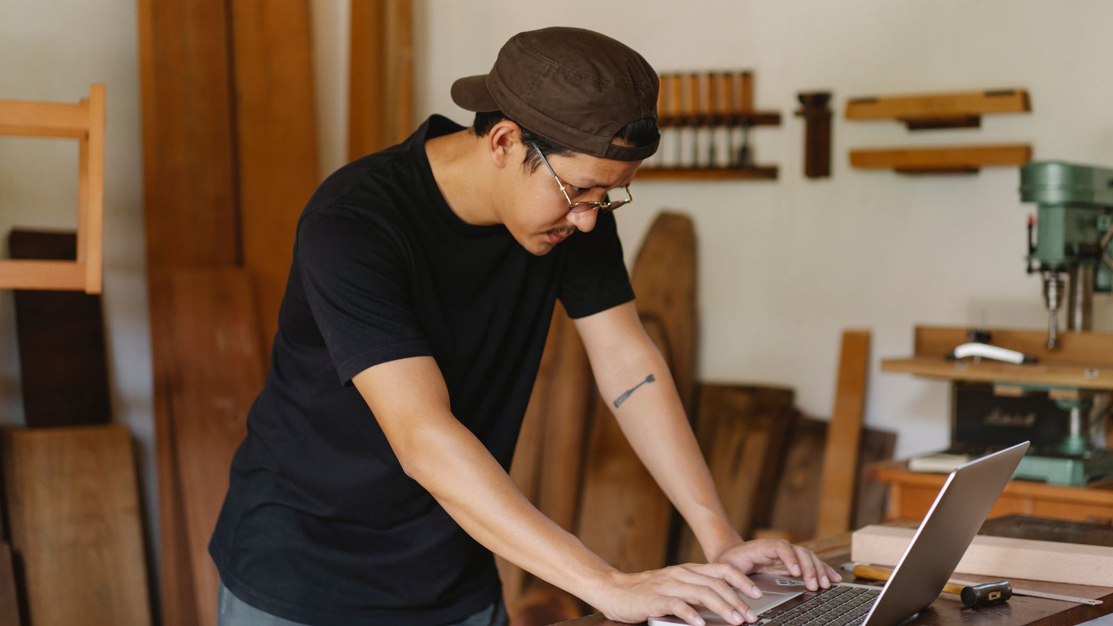 Artisan du bois consultant son ordinateur dans son atelier pour vérifier son futur code APE et NAFA 2027