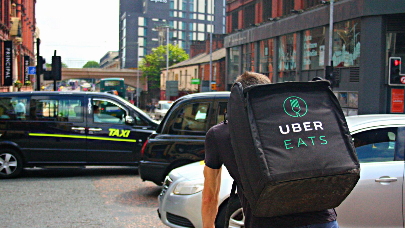 Livreur Uber Eats à vélo dans la circulation urbaine à Manchester