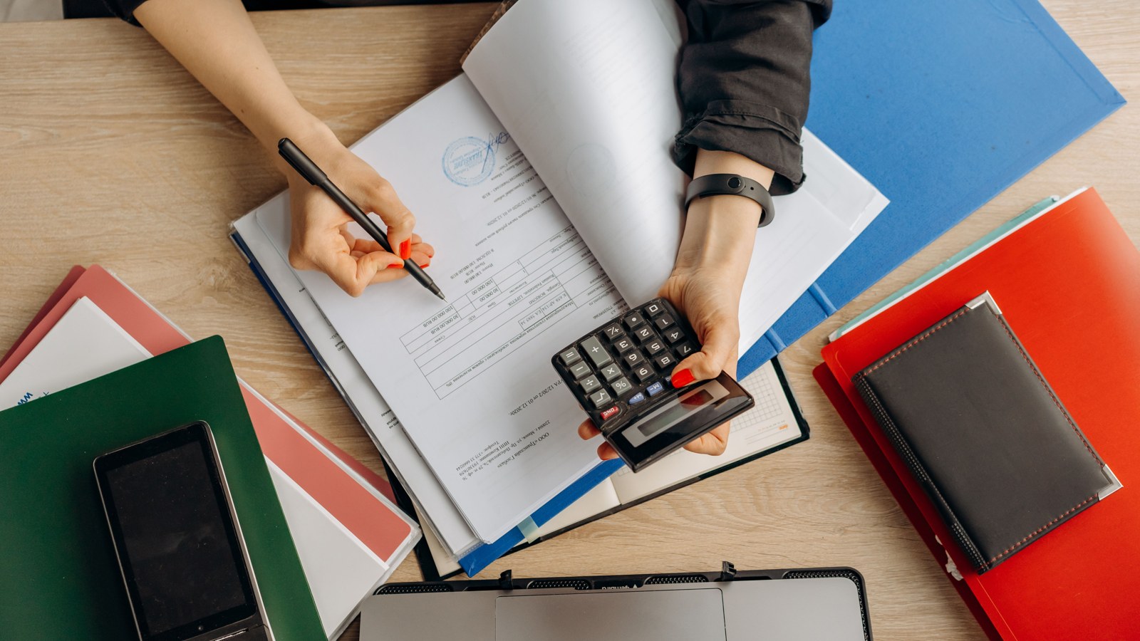 Documents financiers et calculatrice sur un bureau, illustration du suivi de trésorerie